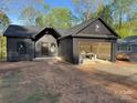 Modern home with dark siding and an attached garage with a gravel driveway at 122 39Th Avenue Nw Ct, Hickory, NC 28601