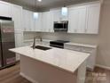 Bright kitchen featuring white cabinets, stainless steel appliances, and a center island with a white countertop at 122 39Th Avenue Nw Ct, Hickory, NC 28601