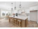 Bright, spacious kitchen with a large center island, modern pendant lighting, and an adjacent dining area at 13097 Arnold Palmer Cir # 844, Lancaster, SC 29720
