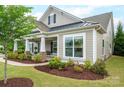 Inviting front porch with stone accents, manicured landscaping and craftsman architectural details at 13103 Union Square Dr, Huntersville, NC 28078
