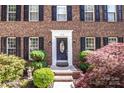Brick home entrance featuring front door flanked by black shutters and manicured landscaping at 145 Meadow Pond Ln, Mooresville, NC 28117