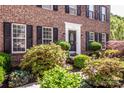 Beautiful home with front door flanked by manicured shrubs and manicured landscaping at 145 Meadow Pond Ln, Mooresville, NC 28117