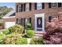 Close up of brick home, highlighting the front door with black shutters and manicured landscaping at 145 Meadow Pond Ln, Mooresville, NC 28117