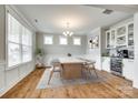 Bright dining room featuring a modern chandelier, beverage center, and ample natural light from large windows at 15312 Ravenall Dr, Huntersville, NC 28078