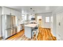 Modern kitchen with stainless steel appliances, white cabinets, an island with seating, and luxury vinyl plank flooring at 1540 Neely Store Rd, Rock Hill, SC 29730