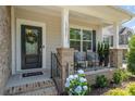 Inviting front porch with seating, decorative plants, and a stylish front door with wreath and welcome mat at 17231 Rider Wood Ln, Charlotte, NC 28278