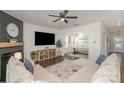 Comfortable living room with a fireplace, ceiling fan, and open access to the dining area at 17231 Rider Wood Ln, Charlotte, NC 28278