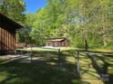 Fenced backyard with a pool house, swimming pool covered for the off-season, and lush greenery at 1855 7Th St, Salisbury, NC 28144