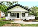 Inviting single-story home with a covered front porch, well-maintained landscaping, and a detached shed at 307 E 2Nd St, Lowell, NC 28098
