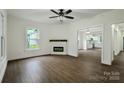 Bright living room featuring hardwood floors, a modern fireplace, and an open layout with kitchen views at 307 E 2Nd St, Lowell, NC 28098