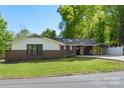 A charming brick home on a sunny day, featuring a carport and lush green lawn, offering serene suburban living at 319 Hatley Ne Cir, Concord, NC 28025