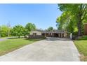 Inviting brick home with a long driveway, covered carport, and landscaped lawn, showcasing convenience and charm at 319 Hatley Ne Cir, Concord, NC 28025