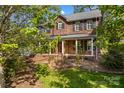 Beautiful brick home featuring a covered front porch, white columns, and classic black shutters at 422 Wildwood Dr, Salisbury, NC 28146