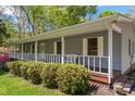 Inviting home showcasing a wide front porch, manicured bushes, and a glimpse of the serene neighborhood at 531 Hattaway Dr, Mount Gilead, NC 27306