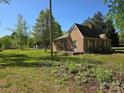 Single story brick home on a sunny, green lot with mature trees at 8860 Castor Rd, Salisbury, NC 28146