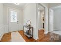 Inviting entryway with decorative table, hardwood floors, and stylish door, leading to other areas of the home at 9565 Horsebit Ln, Concord, NC 28027
