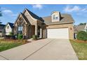 Beautifully landscaped home featuring a brick and stone facade, a two-car garage, and well-maintained lawn at 9565 Horsebit Ln, Concord, NC 28027