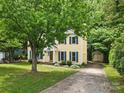 Charming yellow two-story home with blue shutters, lush front lawn, long driveway, and detached shed at 1007 Doby Springs Dr, Charlotte, NC 28262