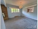 Bright living room with neutral walls, large windows, and a classic chandelier at 1012 Burrage Ne Rd, Concord, NC 28025