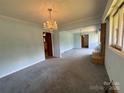 Spacious living room featuring a classic chandelier and view of the fireplace at 1012 Burrage Ne Rd, Concord, NC 28025