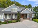 Charming home featuring a cozy porch, stone accents and manicured shrubbery at 1068 Grant Dr, Denver, NC 28037