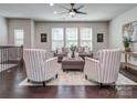 Bright living room featuring stylish seating, a ceiling fan, and large windows at 12214 Ardrey Park Dr, Charlotte, NC 28277
