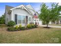 Inviting home with manicured landscaping, American flag, and a two-car garage at 13115 Union Square Dr, Huntersville, NC 28078