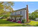 Charming two-story home featuring brick chimney, blossoming trees, and covered front porch at 1321 South Point Rd, Belmont, NC 28012