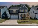 Two-story gray home with white trim, well-kept lawn, attached garage, and a cozy front porch at 1390 Cedardale Ln, Denver, NC 28037