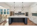 Modern kitchen with white cabinets, stainless steel appliances, tile backsplash and a large center island at 1390 Cedardale Ln, Denver, NC 28037
