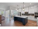 Spacious kitchen with white cabinets, stainless steel appliances, large island and hardwood flooring at 1390 Cedardale Ln, Denver, NC 28037
