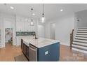 Stylish kitchen boasts marble island, custom cabinets, stainless appliances, and a convenient butler's pantry at 1390 Cedardale Ln, Denver, NC 28037