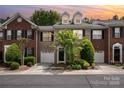 Charming brick townhome featuring a front-entry garage and meticulously landscaped front yard at 14457 Adair Manor Ct, Charlotte, NC 28277