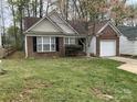 A cozy brick home with a well-manicured front lawn, featuring a single-car garage at 1507 Rumstone Ln, Charlotte, NC 28262