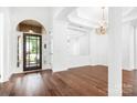Elegant foyer showcasing dark wood floors, chandelier and a beautiful front door at 17408 Summer Place Dr, Cornelius, NC 28031