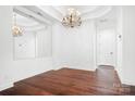 Spacious living room with dark hardwood floors, a large mirror and elegant chandelier at 17408 Summer Place Dr, Cornelius, NC 28031