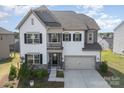 Two-story home with a combination of white siding, a two-car garage and manicured landscaping at 17502 Snug Harbor Rd, Charlotte, NC 28278