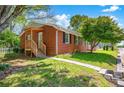 Charming brick home with a welcoming porch and mature landscaping with a walkway leading to the entrance at 218 N Bost St, Statesville, NC 28677