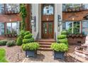 Close-up of the home's entrance featuring a double door, custom planters, and elegant lighting fixtures at 4465 3Rd Nw St, Hickory, NC 28601