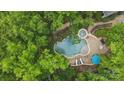 Overhead view of an in-ground pool and spa with patio area surrounded by lush, mature trees at 4561 Walden Pond Trwy, Concord, NC 28025