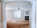 Bright living room featuring a fireplace, neutral carpet, and a large window for natural light at 616 Mountain Quail Dr, Charlotte, NC 28216