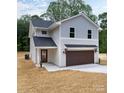 Charming two-story home featuring light gray siding, a dark roof, and a two-car garage at 6223 Rockwell W Blvd, Charlotte, NC 28269