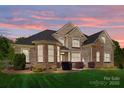 Charming brick and stone home with manicured lawn and pink sunset backdrop at 630 Deberry Holw, Rock Hill, SC 29732
