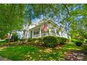 Lovely two-story home with a spacious front porch, an American flag, and a well-maintained lawn at 648 Revival Row, Fort Mill, SC 29708