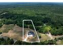 Aerial shot of a sprawling property showcasing a modern farmhouse surrounded by mature trees at 6511 Rehobeth Rd, Waxhaw, NC 28173