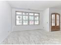 An unfinished living room features an unfinished floor, large windows, and a front entry door at 6511 Rehobeth Rd, Waxhaw, NC 28173