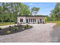 Modern one-story home featuring a gravel driveway and manicured landscaping at 6907 Lancaster Hwy, Waxhaw, NC 28173
