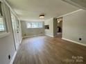 Spacious living room with neutral walls, bright windows, and attractive wood-look flooring at 717 Wilshire Sw Ave, Concord, NC 28025