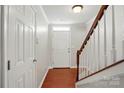 Inviting foyer with hardwood floors, white walls, staircase with wooden handrail, and a white front door at 7753 Jackson Pond Dr, Charlotte, NC 28273
