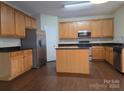 Spacious kitchen with stainless steel appliances, center island, and wood cabinets at 8323 Carolina Laurel Ct, Charlotte, NC 28215